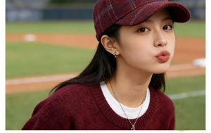 Outdoor model wearing a red plaid baseball cap and warm sweater for autumn fashion