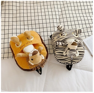 Detailed view of lion and zebra plush backpacks for kids on a cozy checkered background