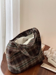 Détail du sac cabas vintage en laine à carreaux avec texture et étiquette en tissu