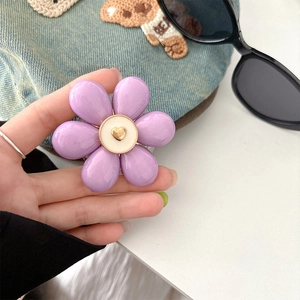 Detail of purple flower phone grip with a golden heart relief on white center disk