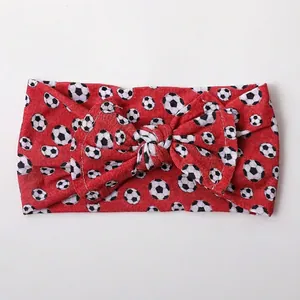 Detail of red baby headband with football print and soft nylon bow design