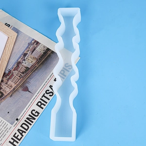 Detailed view of translucent wavy pillar silicone mold for DIY candles on blue backdrop
