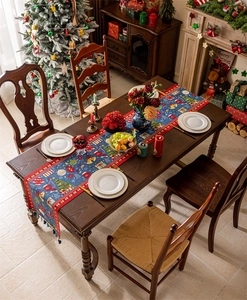 Detailed Christmas table runner with festive tree patterns and tassels on wooden table