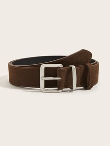 Macro detail of dark brown suede leather belt featuring a matte silver needle buckle