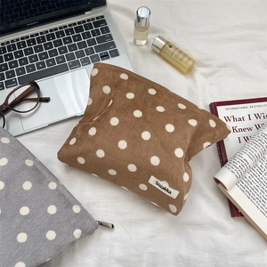 Macro detail of textured corduroy polka dot pouch with high-quality zipper and fabric label