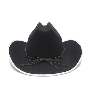Detail of black wool cowboy hat featuring white trim and brown cord bow decoration