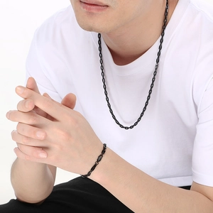 Male model wearing black minimalist hiphop style stainless steel chain necklace and bracelet