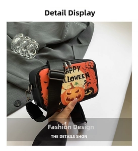 Detail of black Halloween crossbody bag with orange pumpkin print and wide nylon strap