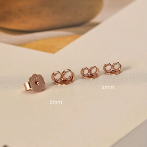 Detailed macro view of 925 sterling silver earring backs in rose gold flower and butterfly shapes