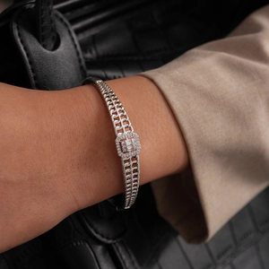 Détail d'un bracelet géométrique argenté avec zircon sur un poignet pour un look élégant