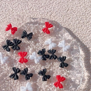 Detailed macro view of mixed matte resin bow charms for nail art in red black and white