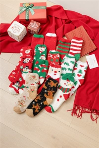 Detailed view of warm Christmas coral fleece socks with festive patterns and gift box