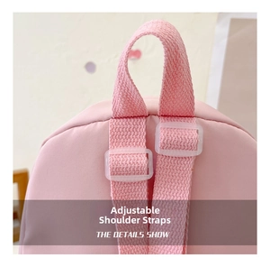 Detail of adjustable woven shoulder strap and plastic buckle on pink children backpack