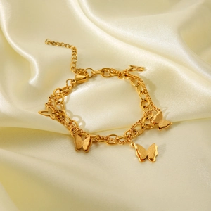 Double-layered 18k gold stainless steel bracelet with butterfly pendants on cream silk