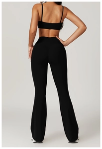 Detail of high-waisted black yoga set with flare pants and strappy sports bra back view
