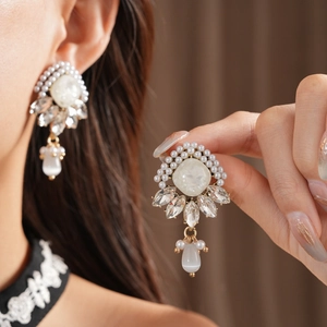 Dettaglio ravvicinato di orecchini vintage stile palazzo con perle e cristalli lucidi