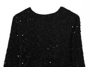 Detailed close-up of the black sequined fabric and round neckline of the mini dress