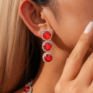 Close-up of elegant gold earrings with vibrant red gems and sparkling diamond accents