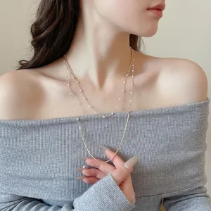 Elegant gold double-layered necklace featuring dainty pearls for a minimalist French chic look