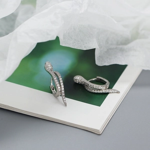 Macro view of silver snake-shaped earrings with micro-pave crystal inlay details