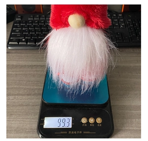 Detail shot of a Christmas gnome doll on a digital scale weighing 99.3 grams