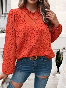 Detail of orange hollow embroidery shirt featuring puff sleeves and ruffle V-neckline