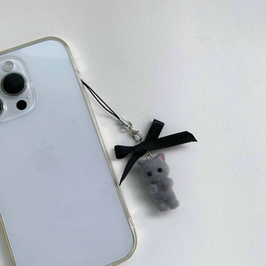Detail of flocked grey kitten charm with black silk bow on a smartphone lanyard