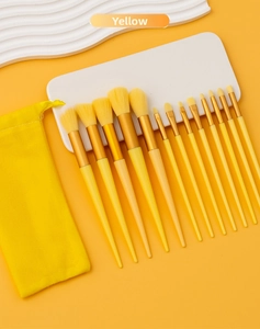 Macro shot of 13-piece yellow makeup brush set with dense bristles and a matching pouch