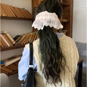 Elegant off-white lace scrunchie with embroidery shown on ponytail in aesthetic setting