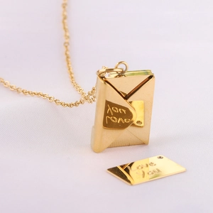 Macro shot of gold envelope pendant necklace with Love You engraving and opening lid