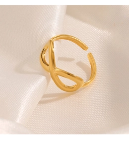 Detailed shot of an 18K gold infinity knot open ring on elegant white silk fabric