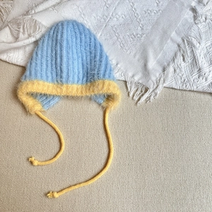 Detail of plush winter trapper hat in sky blue and yellow fleece with cozy earflaps