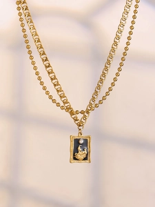 Detailed close-up of vintage gold frame necklace with angel relief and white pearl pendant