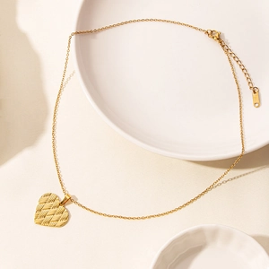 Macro shot of 18k gold plated heart pendant necklace with braided texture detail