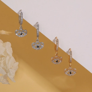 Evil eye hoop earrings in gold and silver finish with zircon stones on split background