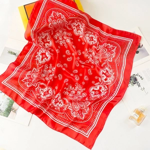 Detail of red paisley silk scarf with satin finish and lifestyle decorative props