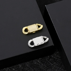 Macro shot of gold zircon-set and silver smooth stainless steel Cuban chain clasps