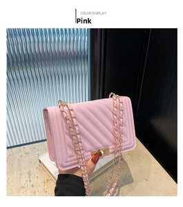 Detail of pink quilted PU leather crossbody bag with gold-tone square lock and chain strap