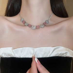 Close-up of silver necklace featuring pink square zircon and clear round gemstones