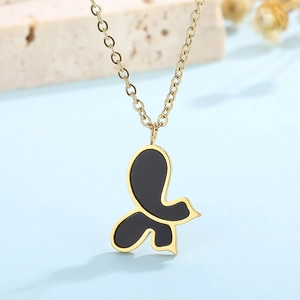 Close-up of golden butterfly necklace with black shell pendant on a blue background