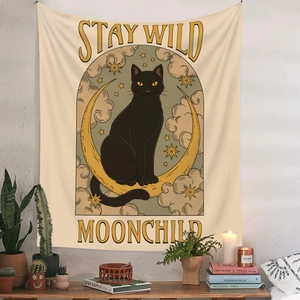 Detail of tapestry with a black cat on a yellow moon featuring Stay Wild Moonchild text