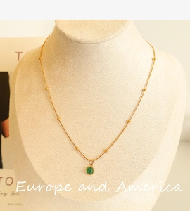 Close-up of green aventurine stone pendant on 18k gold plated snake chain with gold beads