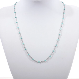 Detailed close-up of a stainless steel bead chain with turquoise enamel accents on a model