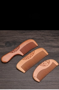Detail showing natural peach wood comb set with traditional floral relief carving