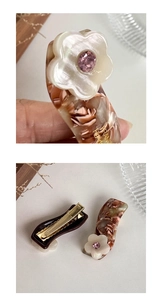 Detail of floral acetate hair clip with pink crystal and golden France Paris engraving