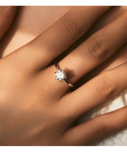 Close-up of a pear-shaped moissanite ring with a brilliant cut on a silver band