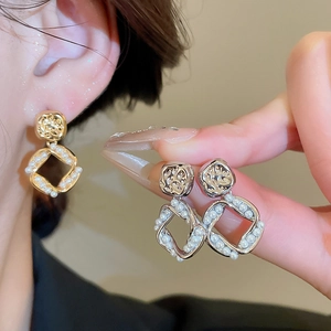Detailed close-up of 18K gold plated textured square earrings with micro pearl accents