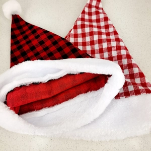 Classic red and black plaid Christmas hats with white plush trim shown from top view