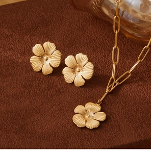 Macro view of golden flower jewelry set with radiating texture on brown velvet surface