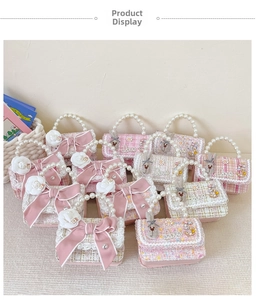 Close-up of pink tweed girls' handbag with pearl handle, bow, and floral ornaments